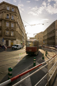 Cars on street in city against sky