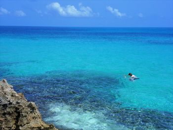 Man swimming in sea against sky