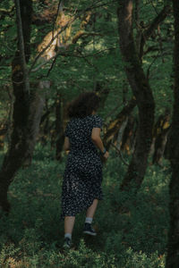 Rear view of woman walking in forest