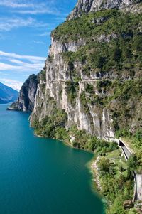 Scenic view of sea by cliff against sky