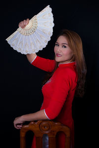 Portrait of a beautiful young woman against black background