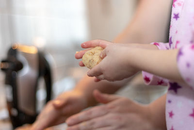 Midsection of woman holding ice cream in kitchen