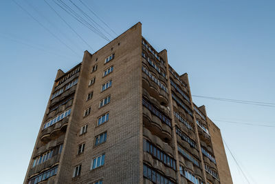 Mid-russian silicate brick condominium residential building, upward view on blue sky background