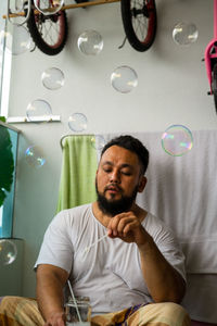 Man blowing bubbles at home