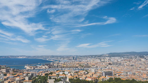 High angle view of townscape by sea against sky