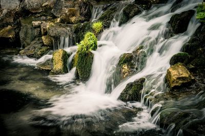View of stream flowing through rocks