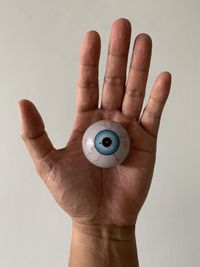 Close-up of person holding hands against white background