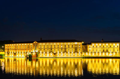 Reflection of building in lake at night