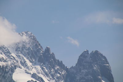 Low angle view of snowcapped mountains against sky