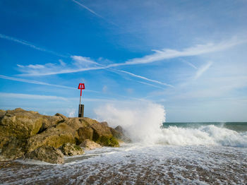 Lighthouse in sea against blue sky