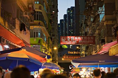 Crowd in city against sky at night