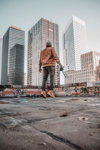 Rear view of man with cityscape in background