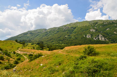 Scenic view of mountains against cloudy sky