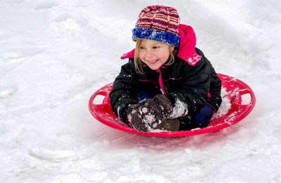 Bright eyed and laughing, this active little girl is really enjoying sledding in michigan