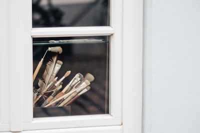 Paintbrushes in container seen through glass window