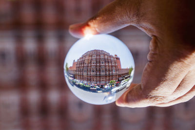 Cropped hand of person holding crystal ball