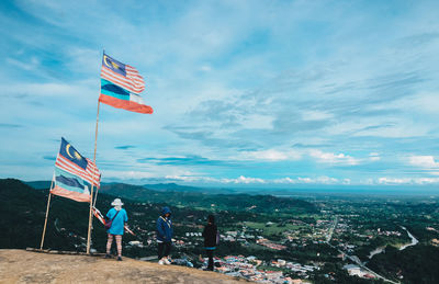 Flag by city against sky