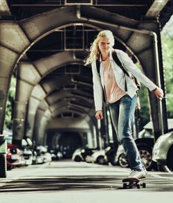 Portrait of young woman skateboarding