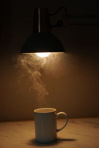 A cup of coffee under a sitting lamp