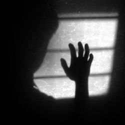 Shadow of person hand on window