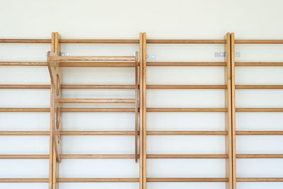 Wooden ladders on white wall in gym