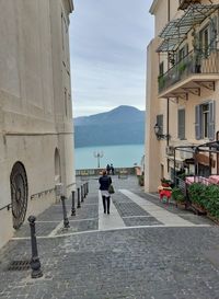 People walking on road amidst buildings in city