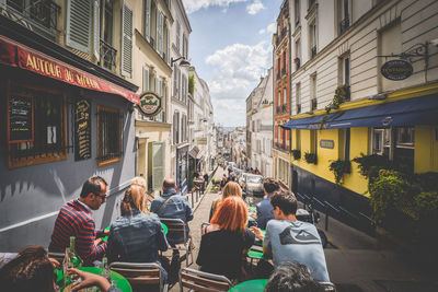 People on street amidst buildings in city