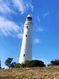 Low angle view of lighthouse by building against sky