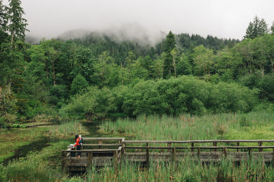 A young couple enjoys a hike on a boardwalk in the pacific northwest.