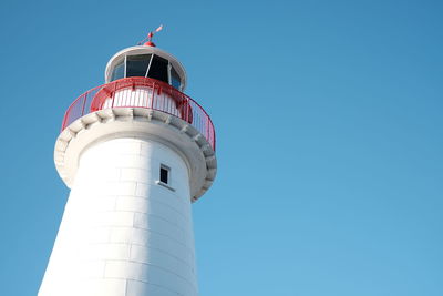 Low angle view of lighthouse against clear blue sky