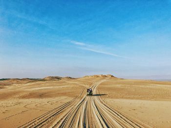 Scenic view of desert against blue sky