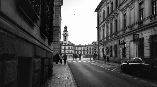 People walking on street amidst buildings in city