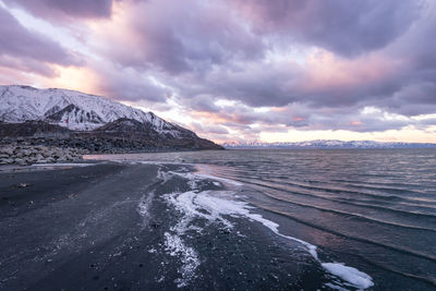 Scenic view of snowcapped mountains against cloudy sky