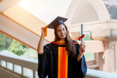 Portrait of young woman standing against the wall