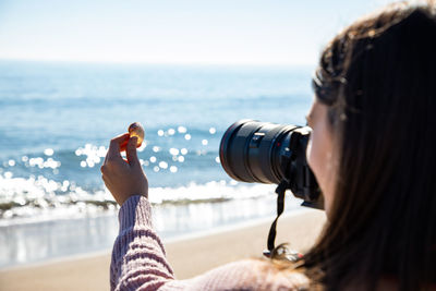 Side view of woman looking at sea against sky