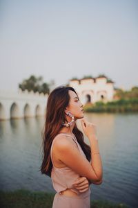 Woman looking away while standing by river