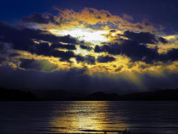 Scenic view of sea against dramatic sky during sunset