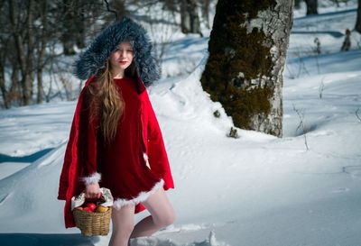 Portrait of girl walking on snow covered land
