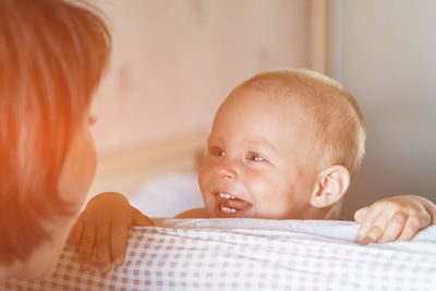 Close-up portrait of cute baby boy on bed