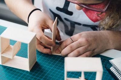 Close-up of young woman working with cardboard on table