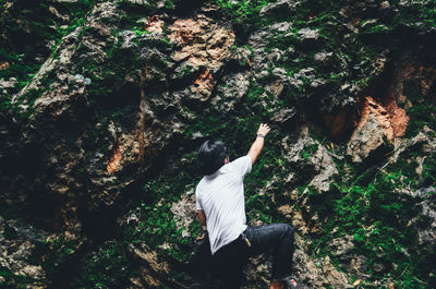 Rear view of man climbing rock