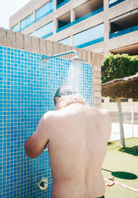 Rear view of shirtless man in swimming pool