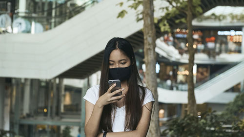 Young woman using mobile phone at camera