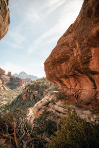 30s female stands on a cliff enjoying views of boynton canyon in sedona.