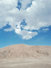 Low angle view of desert against blue sky