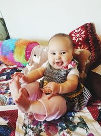 Portrait of happy boy playing on bed at home