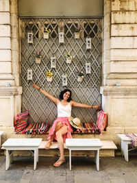 Full length of woman sitting on bench