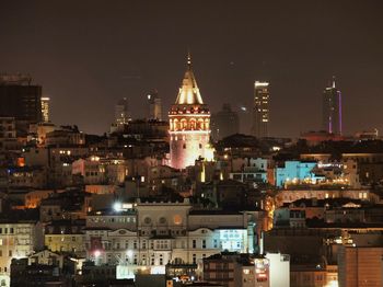 Illuminated cityscape against sky at night