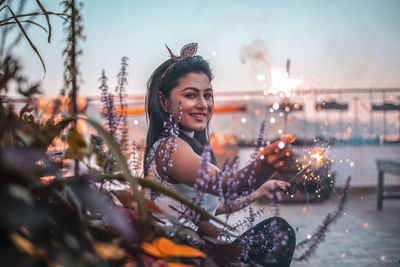 Portrait of smiling young woman sitting outdoors