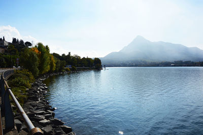 Scenic view of lake by mountains against sky